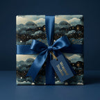 Wrapped Studios luxury gift wrap: Navy blue with gold starbursts and matching satin ribbon.