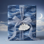 "Sweet Dreams" baby shower gift wrapped in blue night sky wrapping paper with sheer ribbon.