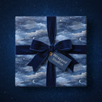 Elegant gift wrapped in blue celestial wrapping paper with velvet bow.