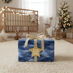 Blue night sky wrapping paper with a gold ribbon and star tag, ideal for Christmas or baby shower gifts.