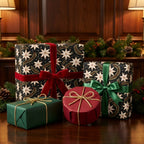 Luxury Christmas gift wrap with cream star patterns, red velvet and green satin ribbons by Wrapped Studios.