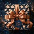 Celestial star wrapping paper by Wrapped Studios with a luxury bronze satin ribbon and Shine Bright tag.