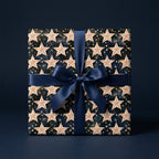 Navy celestial star wrapping paper with a blue satin ribbon, luxury holiday gift wrap by Wrapped Studios.
