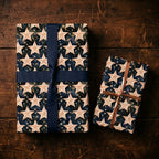 Navy blue celestial star wrapping paper on holiday gifts with ribbons by Wrapped Studios.