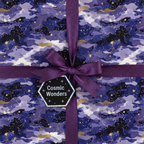 Galaxy wrapping paper in purple with a glittery ribbon bow for birthday gifts.
