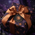 Luxury purple celestial wrapping paper with a bronze satin bow and sun tag by Wrapped Studios.