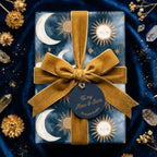 Luxury celestial moon and stars wrapping paper with a gold velvet ribbon by Wrapped Studios.