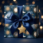 Luxury celestial gift wrap with gold sun and moon pattern and navy blue satin bow by Wrapped Studios.