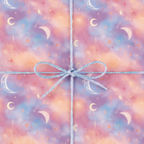 Pastel galaxy wrapping paper with moon and stars design tied with a blue twine bow.