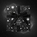 Black celestial wrapping paper with a ribbon and "A Little Starlight For You" tag.