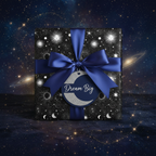 Elegant celestial wrapping paper with blue satin ribbon, "Dream Big" tag, against a galaxy background.