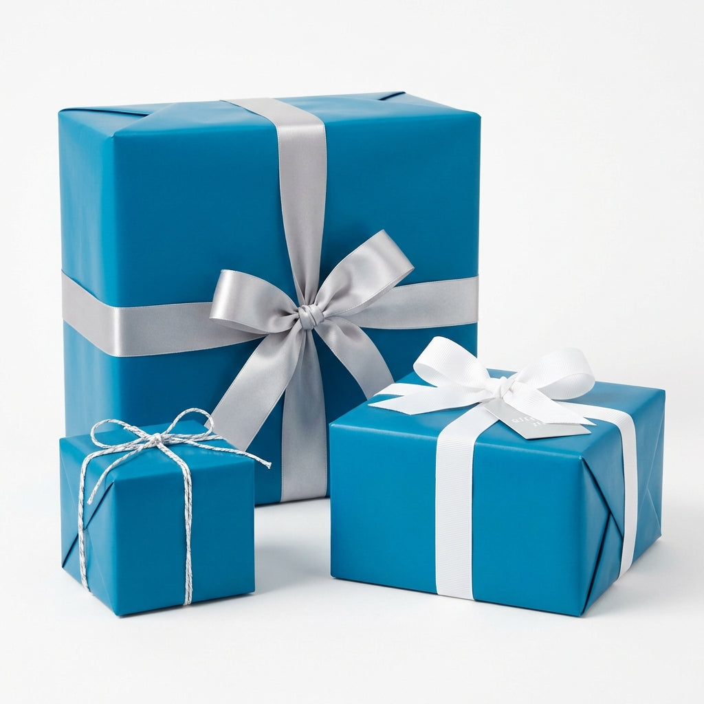 Three square gift boxes wrapped in solid teal paper with white, silver, and string ribbon.