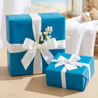 Two teal gifts wrapped in solid color paper with white ribbon and bow.
