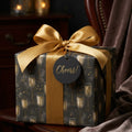 Luxury black and gold champagne wrapping paper with satin bow and Cheers tag by Wrapped Studios.