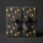 Elegant champagne wrapping paper in black and gold by Wrapped Studios, tied with a black ribbon bow.