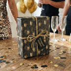 Black and gold champagne luxury gift wrap by Wrapped Studios on a festive New Year's Eve gift box.
