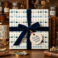 Science gift wrap with watercolor chemistry flasks and a navy velvet ribbon by Wrapped Studios.