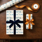 Science wrapping paper with watercolor chemistry beakers on gifts with velvet and satin bows by Wrapped Studios.