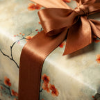 Elegant floral wrapping paper with a bronze ribbon, perfect for a special birthday gift.