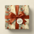 Wrapped Studios floral wrapping paper. Square gift with orange ribbon and delicate blossom pattern.