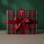 Classic red and green plaid Christmas wrapping paper with a satin bow by Wrapped Studios.