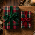 Plaid Christmas wrapping paper on gifts with red and green velvet bows by Wrapped Studios.