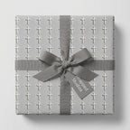 Elegant baptism wrapping paper with a white cross pattern and grey ribbon by Wrapped Studios.