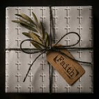 Christian cross wrapping paper with twine, olive branch, and Faith tag. Religious gift wrap by Wrapped Studios.
