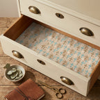 Teal and gold cross wrapping paper used as a vintage drawer liner by Wrapped Studios.