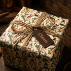 Vintage Christmas gift wrap with holiday apothecary bottles and a rustic twine bow, by Wrapped Studios.