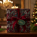 Elegant floral wrapping paper on a gift for Mom, with a burgundy velvet ribbon and Christmas tree in background.