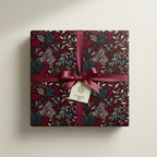 Burgundy floral wrapping paper on square gift box with satin ribbon and "A Special Gift" tag.