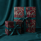 Elegant floral wrapping paper in burgundy with teal ribbon, perfect for Christmas or birthday gifts.
