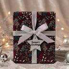 Burgundy Christmas gift wrap with silver ribbon, floral pattern, and "Season's Greetings" tag.