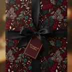 Burgundy floral wrapping paper with black satin ribbon and bow, elegant gift wrap.