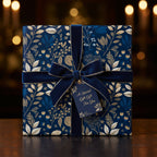 Navy blue floral wrapping paper with gold accents, velvet ribbon, and gift tag for a special gift.