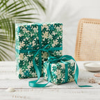 Wrapped gifts with green floral wrapping paper and ribbon, perfect for birthday or tropical-themed occasion.