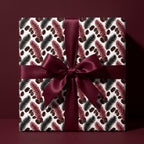 Luxury holiday gift wrap with botanical pattern and burgundy bow by Wrapped Studios.