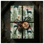 Dog Christmas wrapping paper with watercolor holiday dog pattern, tied with rustic twine by Wrapped Studios.