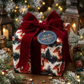 Luxury fantasy Christmas wrapping paper with red dragons and a velvet bow by Wrapped Studios.
