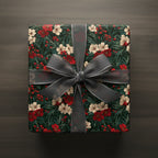 Square gift wrapped in floral Christmas wrapping paper with gray sheer ribbon on wood surface.