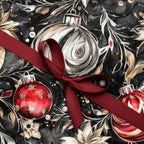 Elegant Christmas wrapping paper with dark floral pattern, ornament accents and red ribbon bow.