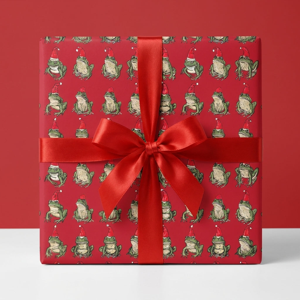 Funny frog Christmas wrapping paper with a red satin bow on a gift box by Wrapped Studios.
