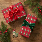 Funny frog Christmas wrapping paper on gifts with red and green ribbons by Wrapped Studios.