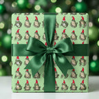 Whimsical frog Christmas wrapping paper with a dark green satin ribbon, by Wrapped Studios.