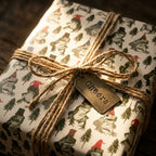 Whimsical frog Christmas wrapping paper with a rustic twine bow and Cheers tag by Wrapped Studios.