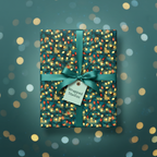 Teal Christmas gift wrap with a vintage string light pattern and satin ribbon.