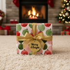 Festive Christmas gift box with red and green ornament wrapping paper, gold ribbon, and a "Merry & Bright" tag on a cozy rug by a fireplace.