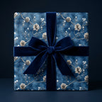 Elegant Christmas gift wrapped in blue floral wrapping paper with a navy velvet bow.