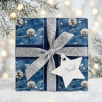 Elegant blue Christmas gift wrap with pinecone pattern and silver ribbon from Wrapped Studios.
